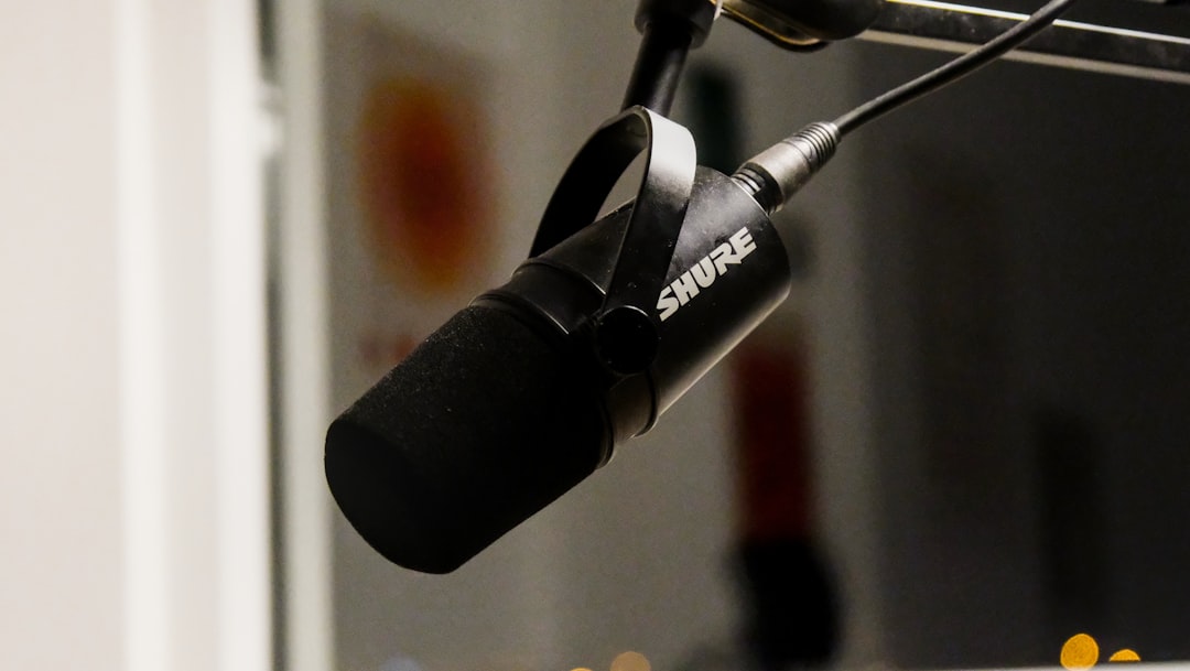 A black shure microphone hangs from a stand.