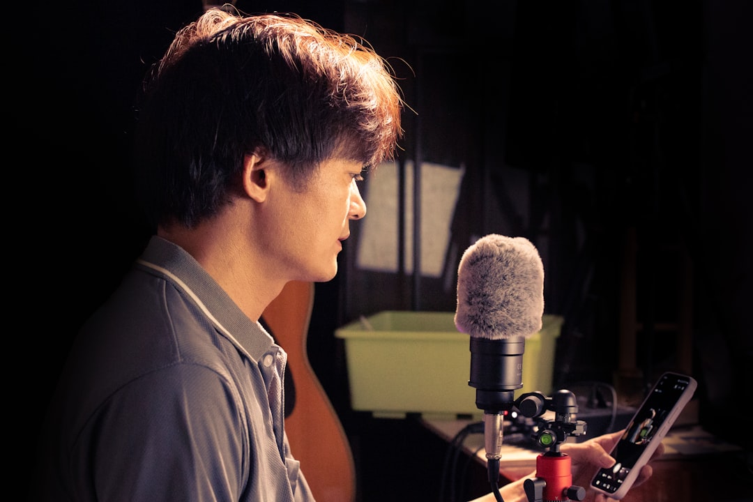 Man recording audio with a microphone and phone.