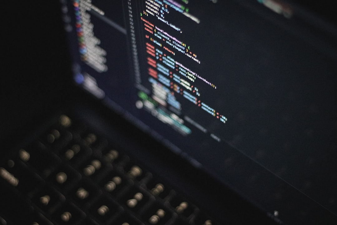 Focused close-up of colorful programming code on a laptop screen, modern software development workspace at night