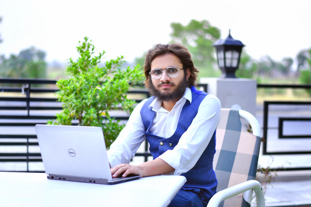 A man sitting at a table with a laptop