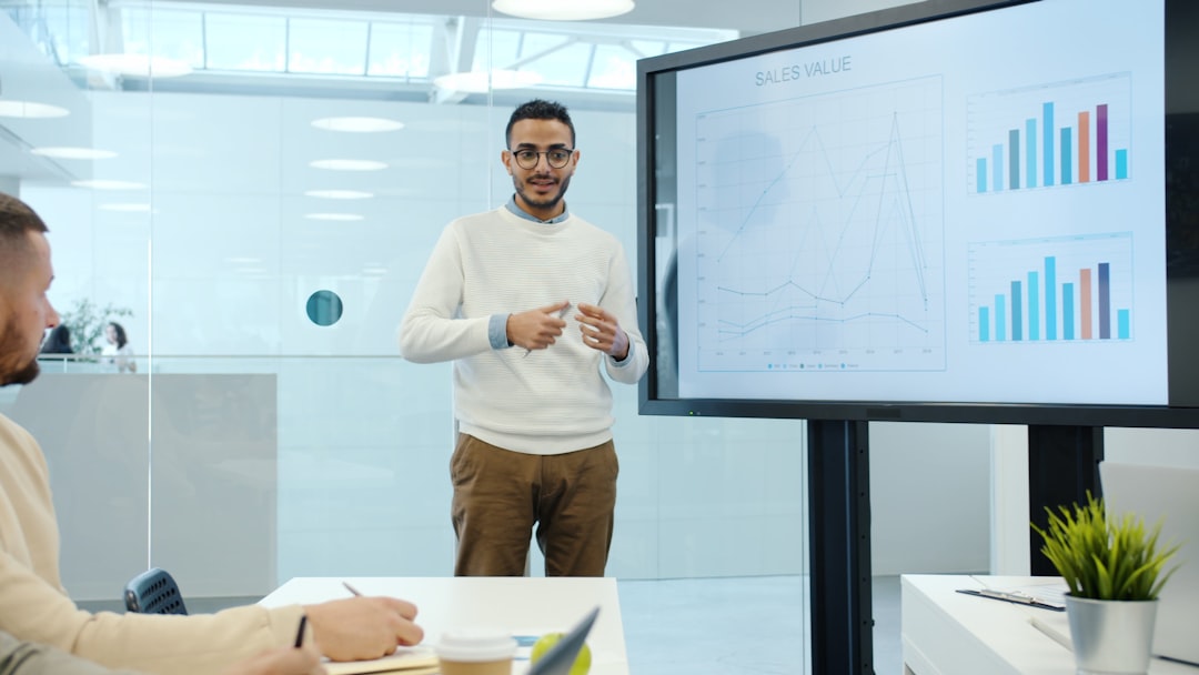 Arab man discussing marketing research with group of people in office using interactive board for presentation talking a